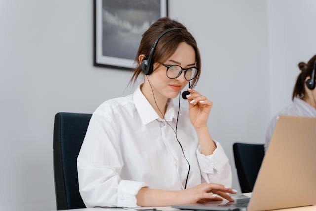 Una especialista con auriculares, respondiendo dudas de clientas por teléfono y correo